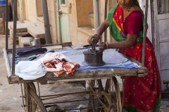 Femme repassant le linge dans la rue